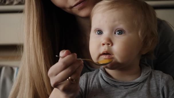 Madre alimentando a una niña pequeña machacada con una cuchara — Vídeos de Stock