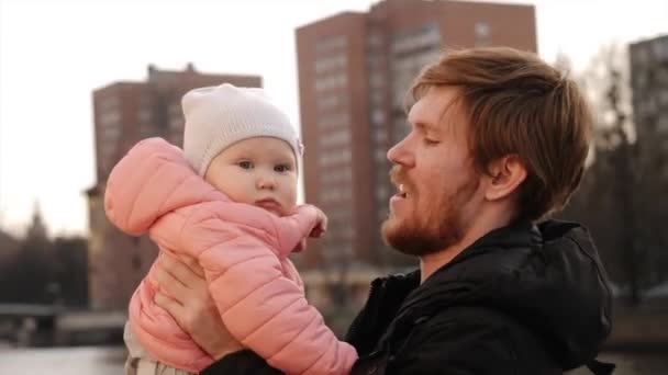 Молодий тато обіймає і кидає маленьку дівчинку — стокове відео