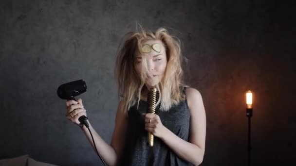 Portrait of a woman dries the hair dryer and sing into your hairbrush — Stock Video