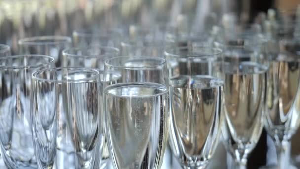 Hodně sklenic se šampaňským se šumivým vínem na hostině — Stock video