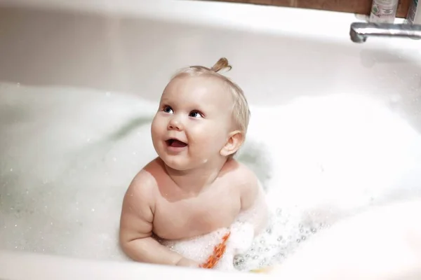 Portret van een schattige baby baden in een bad met schuim closeup Stockfoto