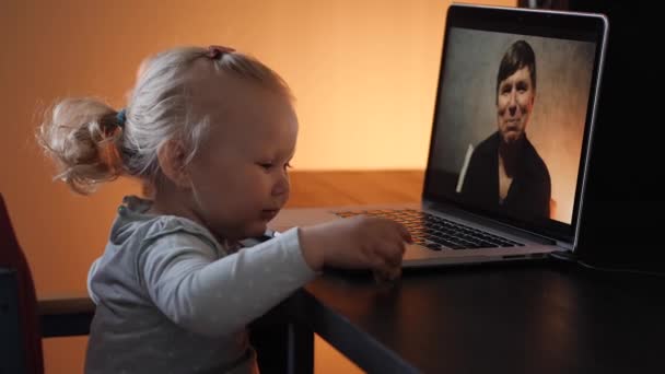 La niña en el video en el portátil saludando al abuelo en línea — Vídeo de stock