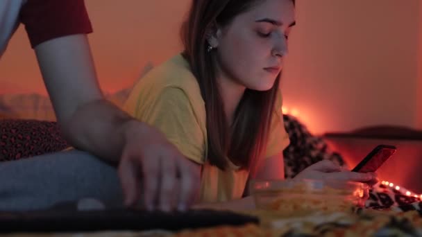 Молода жінка поруч з чоловіком дивиться на соціальні мережі смартфона — стокове відео