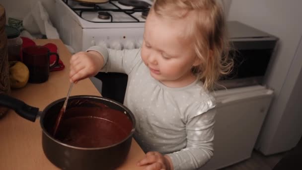 Μικρό χαρούμενο κορίτσι αναμιγνύει ζύμη σοκολάτας για μπισκότα — Αρχείο Βίντεο