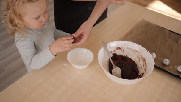 Mamá ayuda a su hija a cocinar galletas de chocolate — Vídeo de stock
