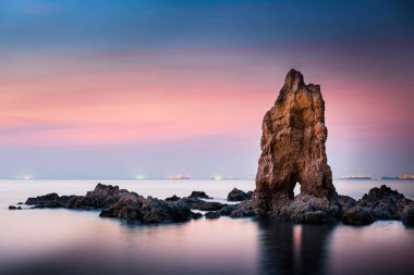 Deniz kaya günbatımı arka plan üzerinde güzel bir sahne.