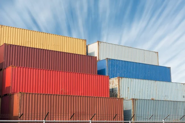 Coloré de la pile de conteneurs sur fond bleu ciel . — Photo