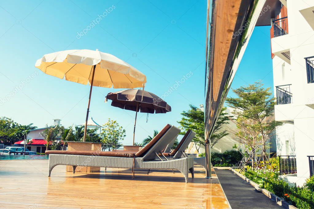 Swimming pool and outdoor bed on sunny day.