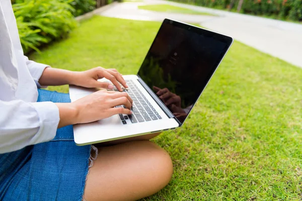 Bahçede açık bilgisayar dizüstü kullanarak iş kadını