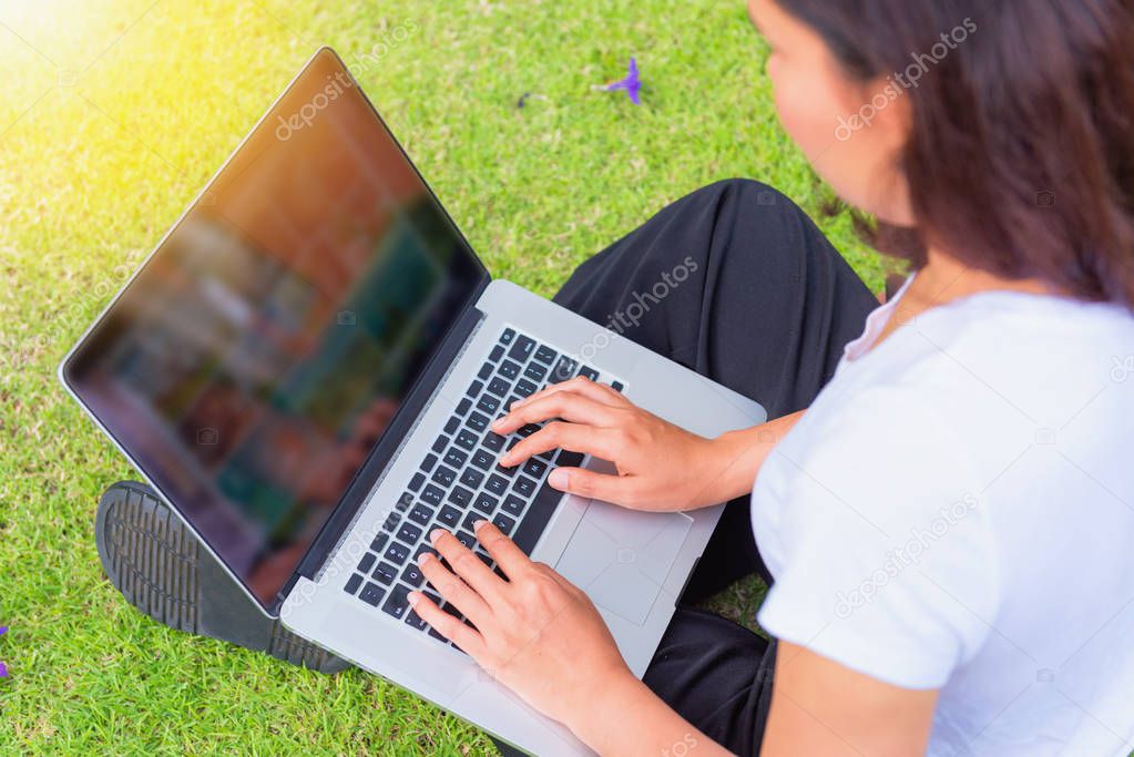 Portrait of young woman using her computer laptop on the garden 