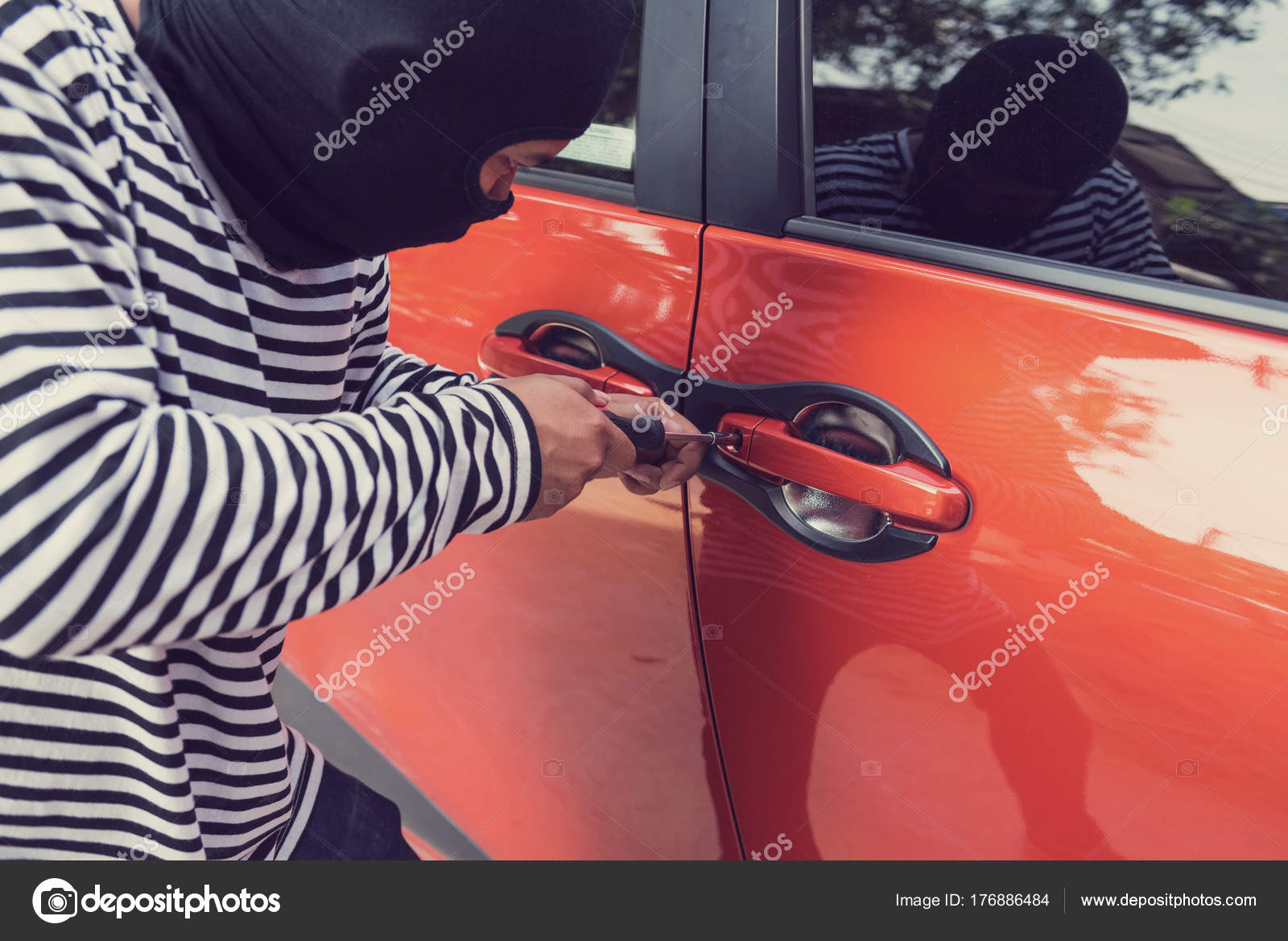 Car Thief Trying To Unlock A Car By Screwdriver Stock