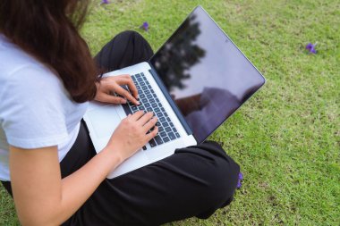 Bahçede açık bilgisayar dizüstü kullanarak iş kadını