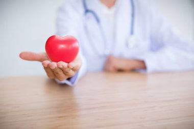 Kadın doktor stetoskop giyen ve kırmızı kalp, tıp holding