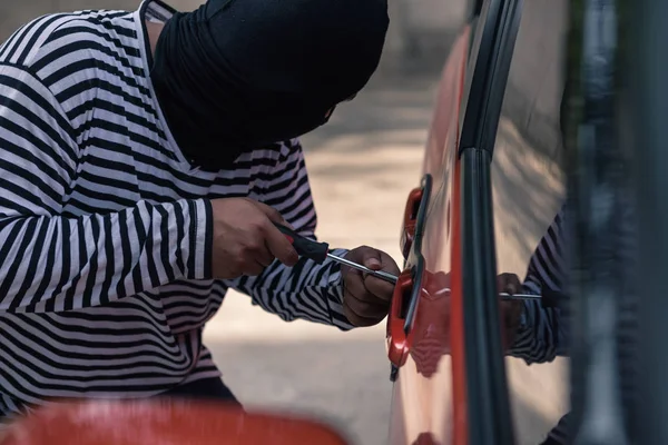 Ladrón de coches tratando de desbloquear un coche por destornillador — Foto de Stock
