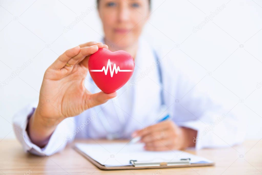 Portrait of woman doctor with holding red heart, Healthcare