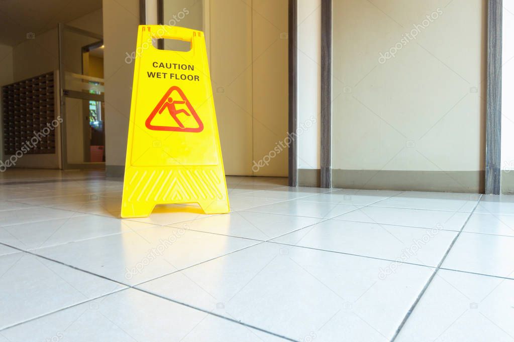 Cleaning and caution wet flooring signboard on the floor