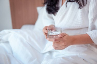 Bir bardak su tutarak onun yatak odasında uyanma kadın