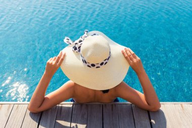 Asyalı kadın ile sunbathe yüzme havuzunda rahatlatıcı