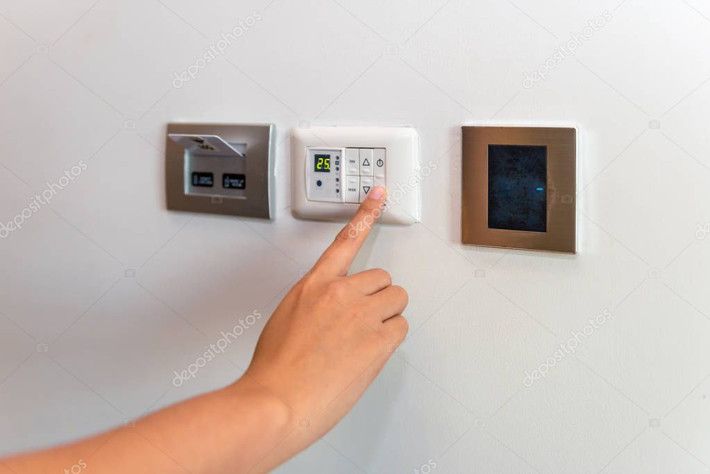 Close up of female hand swiching temperature airconditioner 