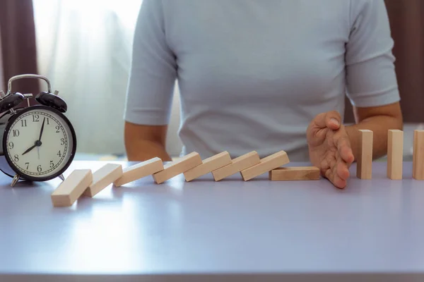 Affärskvinna åtgärd hand stoppa Domino effekt — Stockfoto