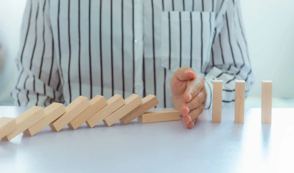 Affärskvinna åtgärd hand stoppa Domino effekt — Stockfoto