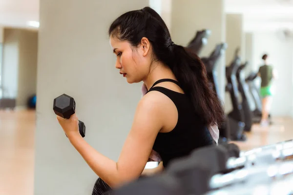 Retrato de mujer asiática levantando pesas en gimnasio — Foto de Stock