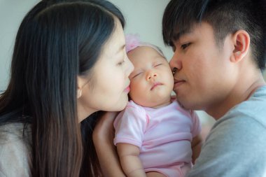 Babası ve annesi küçük bir bebek, ebeveynlik öpüşme