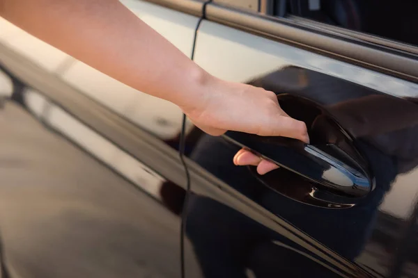 Retrato de cerca de la mano de la mujer que sostiene la manija para abrir un coche — Foto de Stock