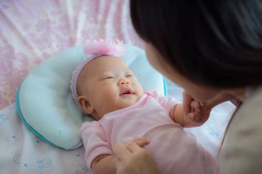 Anne ve gülüyor, birlikte yatak odasında oynarken küçük bebek