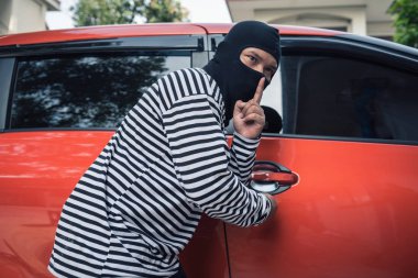 Tornavida tarafından bir arabaya girmeye çalışan araba hırsızı