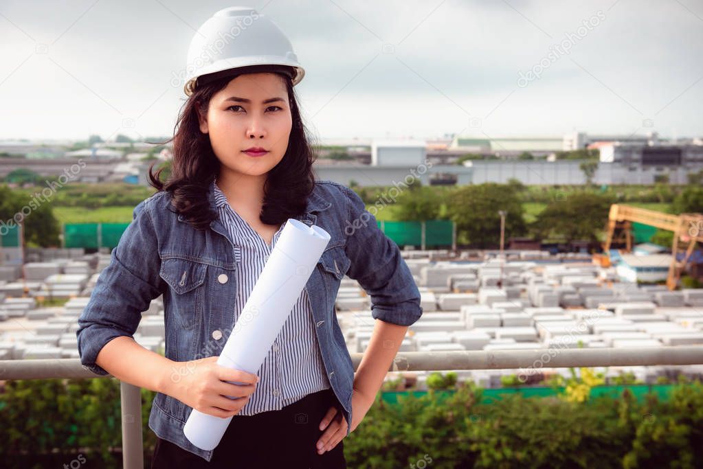 Portrait of engineer woman in front of factory background