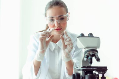 Mikroskop bir laboratuvar. içinde biyoteknoloji, bilim, kimya kullanarak genç bilim adamı araştırma portresi.