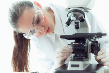 Mikroskop bir laboratuvar. içinde biyoteknoloji, bilim, kimya kullanarak genç bilim adamı araştırma portresi.