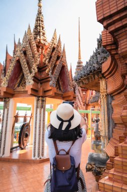 Tapınağı gezerken eğlenen Turist Kadın, Dinsel İbadet Antik Mimarisi ile Buda Heykeli 'nin fotoğrafını çekerken Asyalı Kadın Rahatlıyor ve Eğleniyor. Seyahat Keşfi 