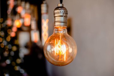 Açık gri soyut arkaplanda asılı klasik bir ampul. Yatay görünüm telif uzayı