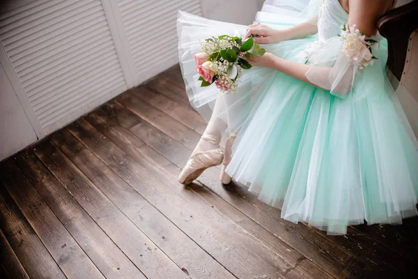 Ballet dancers feet on studio floor. Teenage dancer puts on ballet pointe shoes. Elegance and balance concept top horizontal view copyspace.