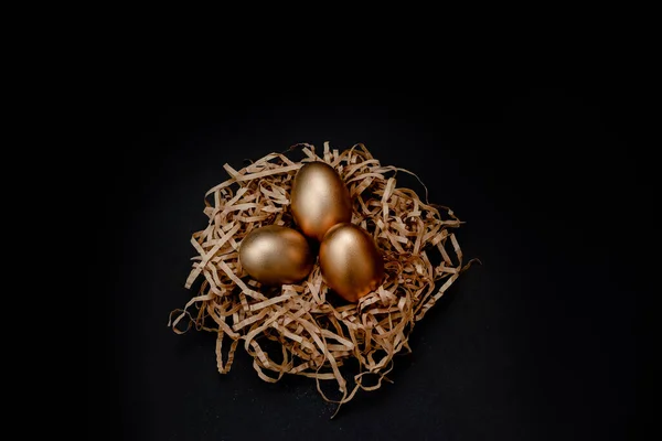 Ostereier golden verziert im Nest auf weißem Hintergrund. Minimales Osterkonzept kopiert Platz für Text. Horizontale Ansicht von oben, flach. — Stockfoto