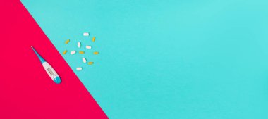 Beyaz tıbbi koruyucu maske, haplar ve mavi arka planda termometre. Coronovirus önleme ve sağlık hizmeti kavramı. Üst yatay görünüm telif uzayı