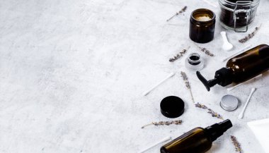 Hassas cilt bakımı kozmetik dişi bezi. Yüz kremi, cam şişeler ve kozmetik, pamuk çubukları ve desenli mermer masa zemininde kurutulmuş lavanta içeren kavanozların yaratıcı bileşimi 