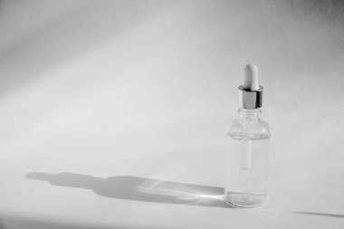 Hyaluronik asit damlası transparant cam şişe. Cilt bakımı ve sağlık konsepti. Beyaz arka planda sulu bir şişe.