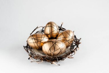 Beyaz arka planda yuvada Paskalya altın madalyalı yumurtalar. Metinler için minimum paskalya konsepti kopyalama alanı. Üst yatay görünüm, düz görünüm.