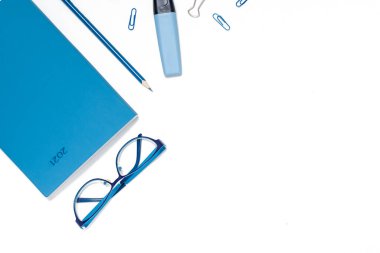 Okul konseptine geri dönelim. Renkli düz yatak. Kalemler, not defterleri, cetvel makasları ve ataçlar. Yatay görünüm kopyalama alanı