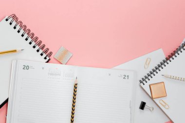 Mockup planlayıcı düz, üst yatay görünüm pembe zemin. Not defteri ve sabit not defterleri. Altın, beyaz, pembe ve siyah c