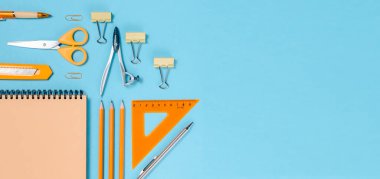 Okul konseptine geri dönelim. Renkli düz yatak. Kalemler, not defterleri, cetvel makasları ve ataçlar. Yatay görünüm kopyalama alanı