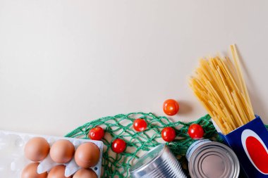 Gıda malzemeleri ve karantina teslimatı soyut bir arkaplanda. Yalnızlık kavramı. Konserve yiyecekler, makarna, domates Copyspace.