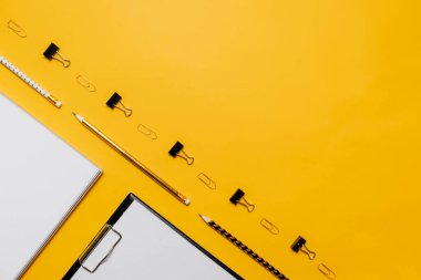 Mockup planlayıcı düz, üst yatay görünüm sarı arkaplan. Not defteri ve kırtasiyeli defterler. Altın, beyaz ve siyah renkler. Okula dönmek, eğitim kavramı..