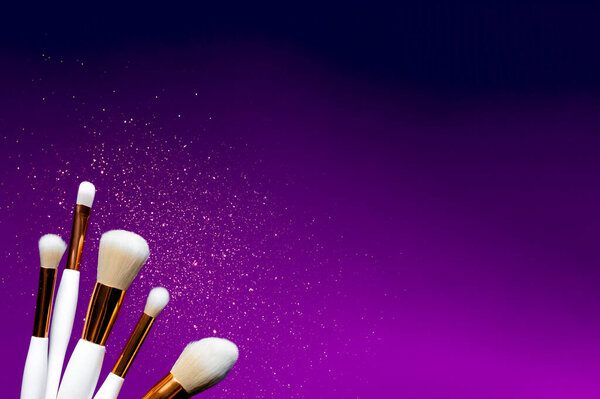 Макияж плоский лежа кисти желтый и фиолетовый фон. Пространство для копирования сверху. Красота и макияж
