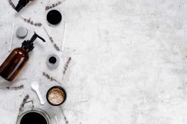 Hassas cilt bakımı kozmetik dişi bezi. Yüz kremi, cam şişeler ve kozmetik, pamuk çubukları ve desenli mermer masa zemininde kurutulmuş lavanta içeren kavanozların yaratıcı bileşimi