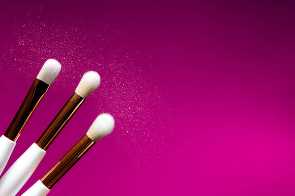 Макияж плоский лежа кисти желтый и фиолетовый фон. Пространство для копирования сверху. Концепция красоты и макияжа
