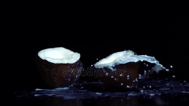 Kokosnoot gebroken in slowmotion op zwarte achtergrond — Stockvideo